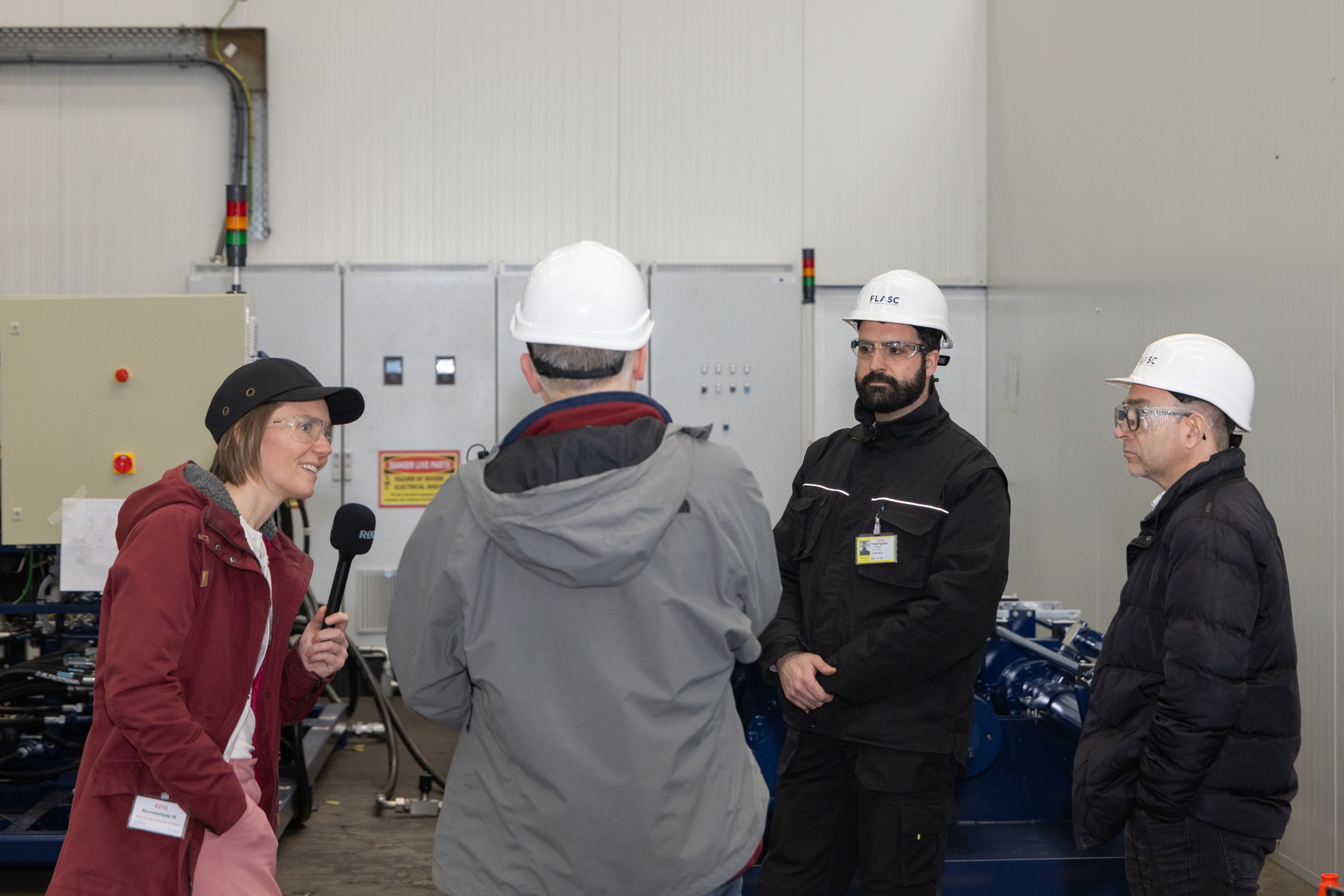 Reportage Offshore Storage: overleg met helmen op de werkvloer van de fabriekshal