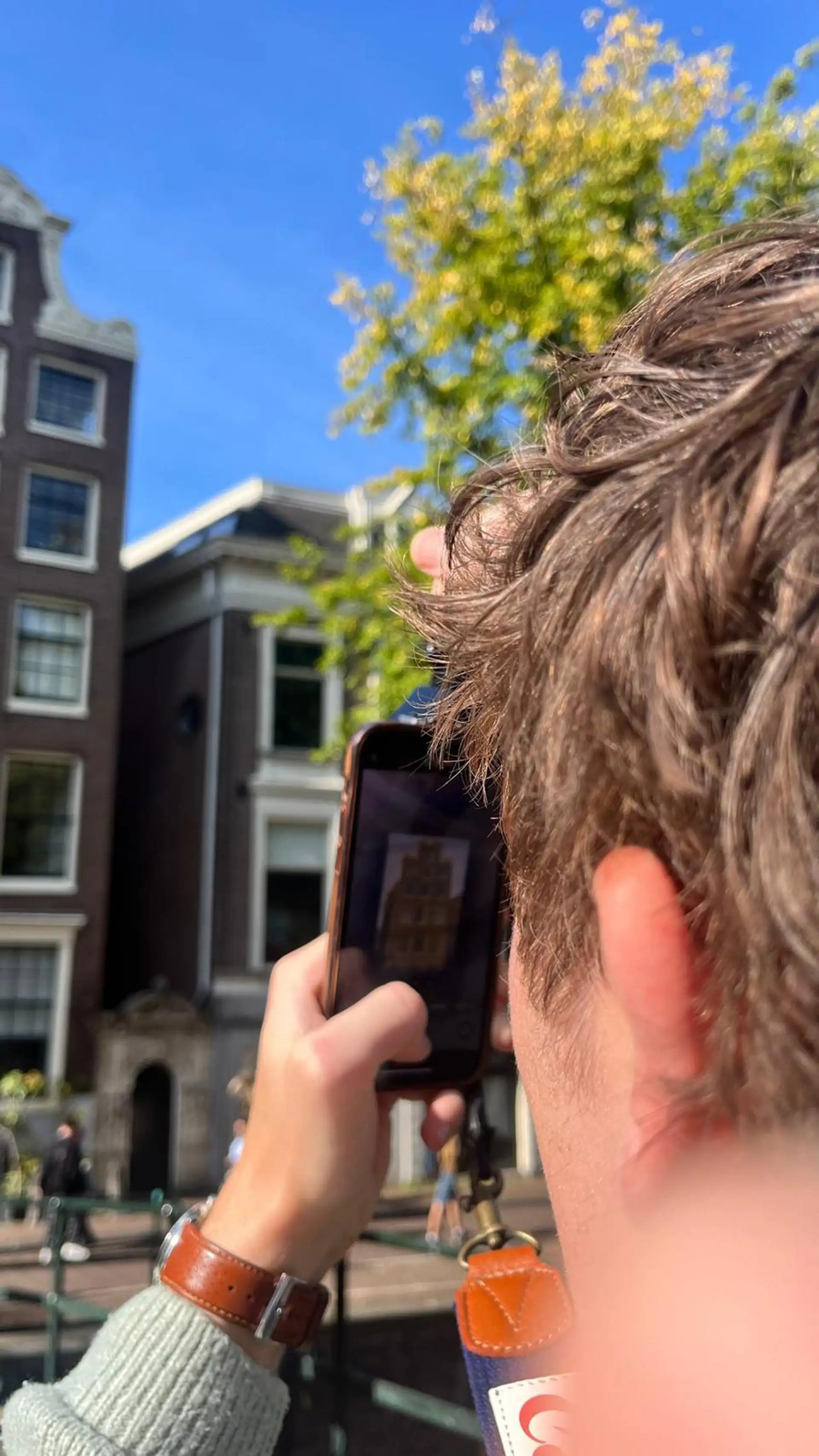 Toerist fotografeert met een smartphone in Amsterdam tijdens de fotowandeling